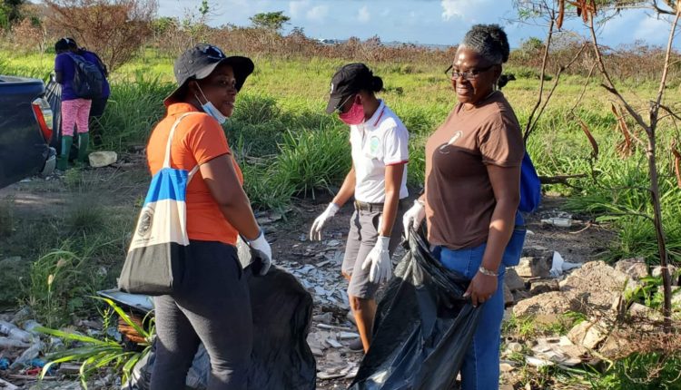Director in Department of Environment, Ms June Hughes (right) with Ms Phynora Ible (centre) and Ms Cheryl Jeffers, collecting garbage on the Basseterre Valley Aquifer.
