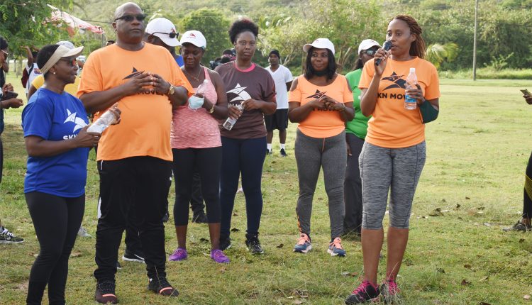 Minister of Health the Hon Akilah Byron-Nisbett (right) addressing SKN Moves Health Walk participants at the Frigate Bay lawns. Prime Minister Harris is second left.
