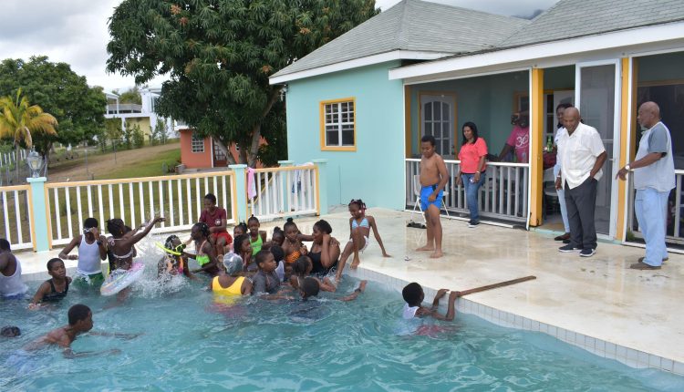 Mr Richard Caines (2nd right) at his Nevis home with pupils of the Dr William Connor Primary School, Basseterre, whom he treated to a special Nevis excursion in April last year.
