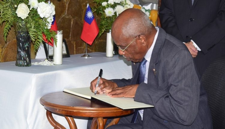 Sir Kennedy signs the book of condolences