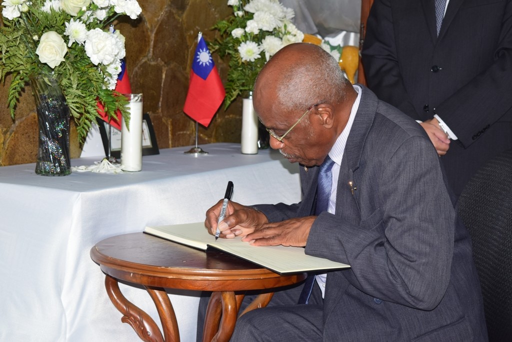Sir Kennedy signs the book of condolences