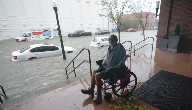 A man watches floodwaters, Wednesday, Sept. 16, 2020, in downtown Pensacola, Fla. Hurricane Sally made landfall Wednesday near Gulf Shores, Alabama, as a Category 2 storm, pushing a surge of ocean water onto the coast and dumping torrential rain that forecasters said would cause dangerous flooding from the Florida Panhandle to Mississippi and well inland in the days ahead. (AP Photo/Gerald Herbert)