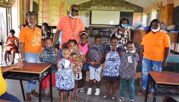 Ambassador Kevin ‘Ninky’ Williams with pupils at the Newton Ground Primary School pictured along with some members of the team that assisted with the distribution.