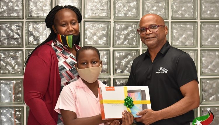 Minister Grant (R) Delivers Tablet To Scholarship Recipient