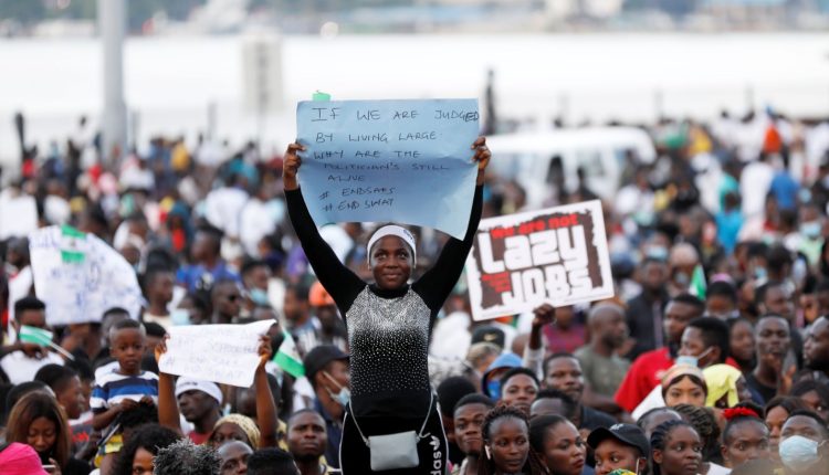 A demonstrator holds a sign during protest over alleged police brutality in Lagos, Nigeria, on 17 October photo via SKY News