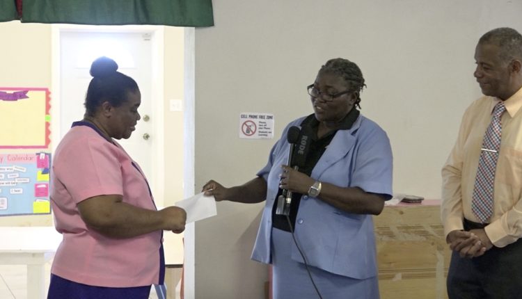 (l-r) Ms. Pamela Elliott, Supervisor of the Gingerland Preschool accepting a cheque from Ms. Dawnny Lanns, Education Officer responsible for the Gingerland Preschool donated by Hon. Eric Evelyn, Minister of Youth and Community Development in the Nevis Island Administration, and area representative for St. George’s, Gingerland on October 09, 2020, while Mr. Evelyn looks on