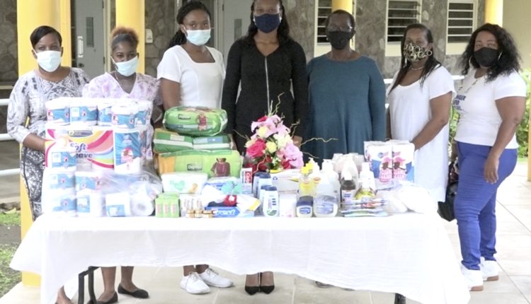 Members of the Concerned Citizens Movement Women’s Arm with their donation of personal care items to  residents of the Flamboyant Nursing Home with  Registered Nurse Kella Didier (third from left) who is attached to the Home