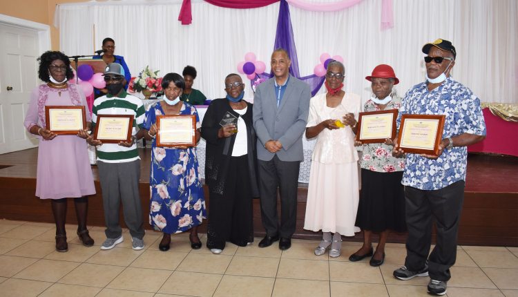The awardees and Minister Evelyn, L-R: Ms Constantia David, Mr Reuben Williams, Mrs Violet Perkins, Mrs Essie Delashley, the Hon Eric Evelyn, Mrs Janet Herbert, Ms Bernadette Lewis, and Mr Carlton Pinney.