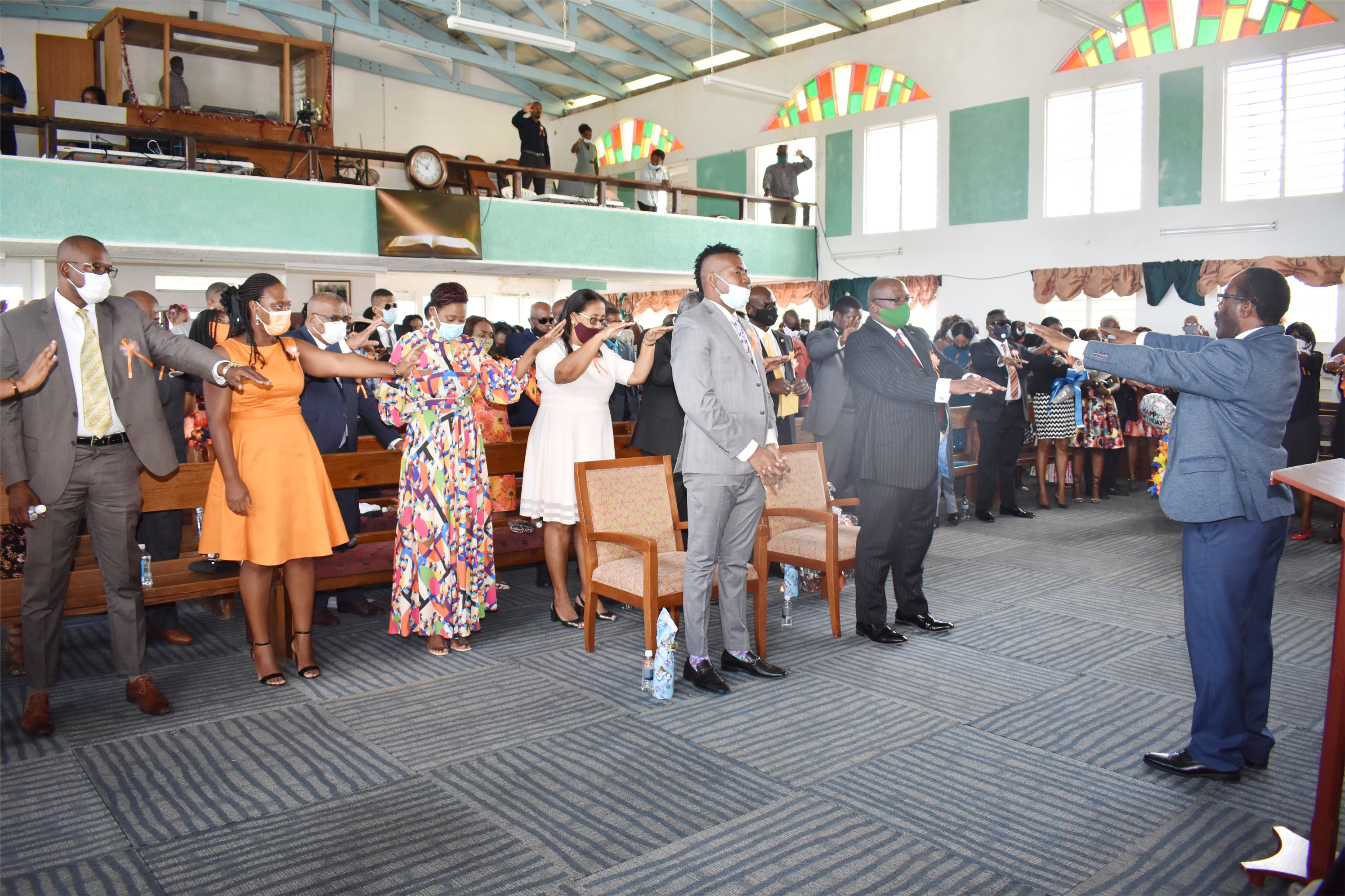 Pastor Michael Penny (right) leads the congregation in offering prayers for the celebrant, Prime Minister Dr the Hon Timothy Harris.