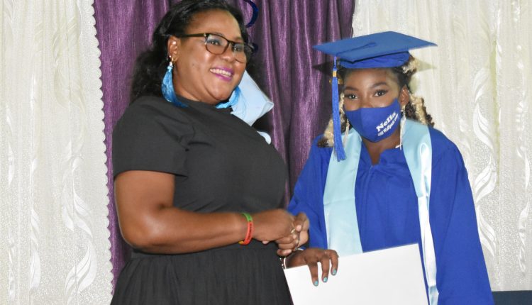 Saddlers Secondary School’s Principal, Mrs Julia Byron-Isaac, making a presentation to one of the top performers, Miss Janella Belle, who returned passing grades in the ten subjects that she sat.