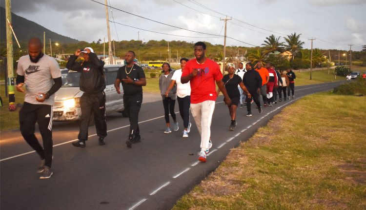Prime Minister Harris is seen among a group of walk participants as they walked along the Island Main Road in Tabernacle Village.