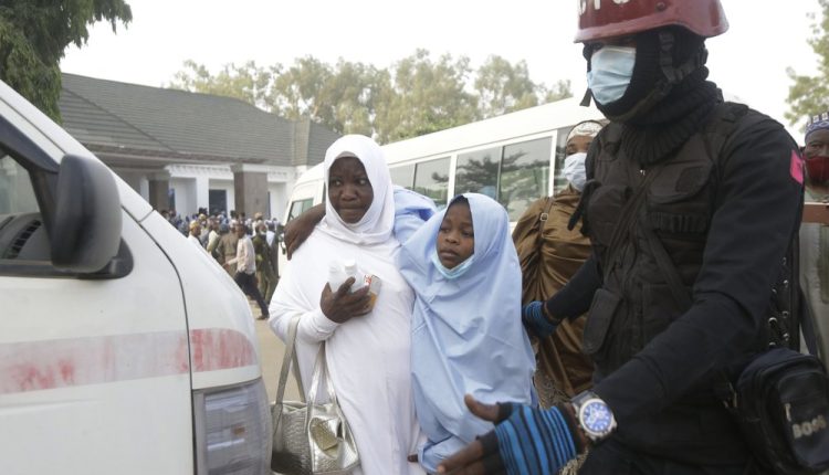 A girl is helped as some of the students who were abducted by gunmen from the Government Girls Secondary School, in Jangebe, last week wait for a medical checkup after their release meeting with the state Governor Bello Matawalle, in Gusau, northern Nigeria, Tuesday, March 2, 2021. Zamfara state governor Bello Matawalle announced that 279 girls who were abducted last week from a boarding school in the northwestern Zamfara state have been released Tuesday.(AP Photo/Sunday Alamba)