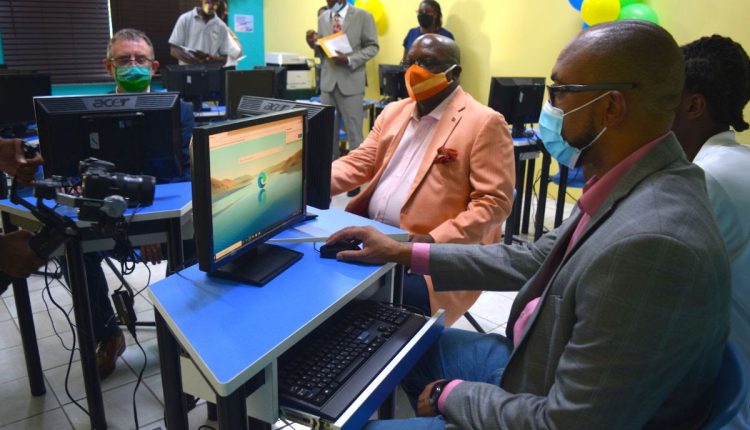 Dean of the Ross University School of Veterinary Medicine, Dr. Sean Callanan (left); Prime Minister Dr. the Hon. Timothy Harris (center), and Minister of Education, the Hon. Jonel Powell (right) browse the computers in one of the newly donated computer labs