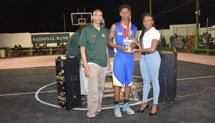 Ms Chantelle Rochester presents second place trophy to Cecil Angel of Bird Rock Uprisers, who was also the league’s MVP. Looking on is SKABA President, Glenville Jeffers.