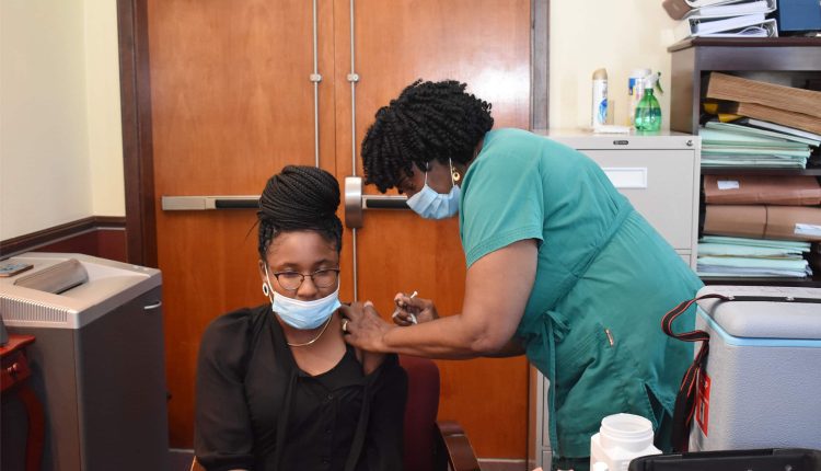 Marketing and Product Development Officer at the Development Bank of St. Kitts and Nevis, Ms Chantelle Rochester, was the first Bank staff member to get the jab from Nurse Merle Hodge.