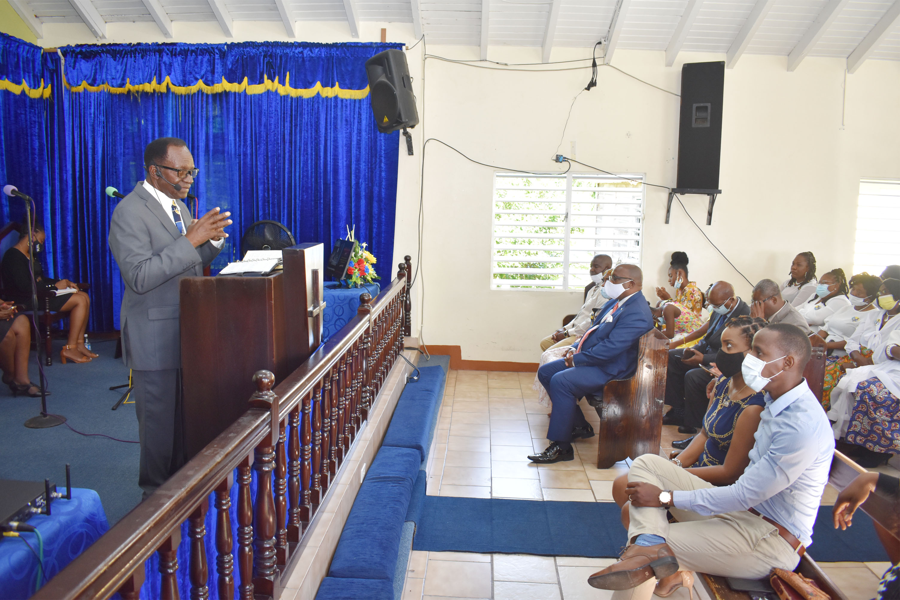 Pastor, Reverend Dr Ben Browne delivering the sermon at the Cayon Church of God on Sunday March 14. Prime Minister Dr the Hon Timothy Harris is seated on the front row to the left.