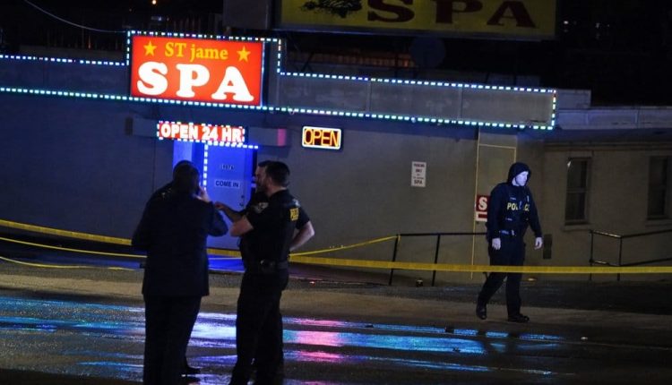 Law enforcement officials confer outside a massage parlor following a shooting on Tuesday, March 16, 2021, in Atlanta. Shootings at two massage parlors in Atlanta and one in the suburbs have left multiple people dead, many of them women of Asian descent, authorities said Tuesday. (AP Photo/Brynn Anderson)