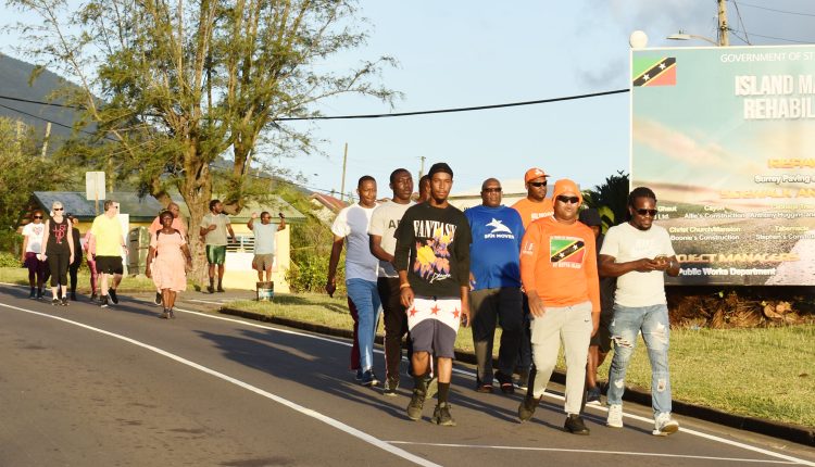 Physical activity is good for your health: Prime Minister Harris (wearing blue SKN Moves shirt) who has been preaching that message leads by example and is seen walking past Mansion Village.