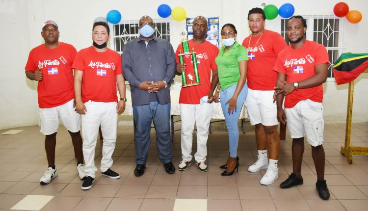 Prime Minister Dr the Hon Timothy Harris, and Development Bank’s Ms Chantelle Rochester with winning team, Los Fuertes del Domino. Holding the trophy is Captain Mr Victor Caines.