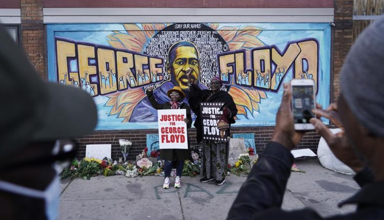 People pose for pictures in front of a mural for George Floyd after a guilty verdict was announced (Photo: AP News)